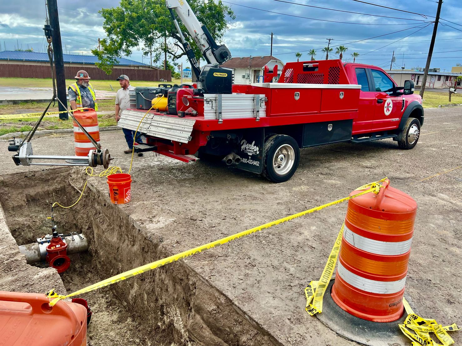 Koppl service truck and crane staged over an emergency pipeline excavation