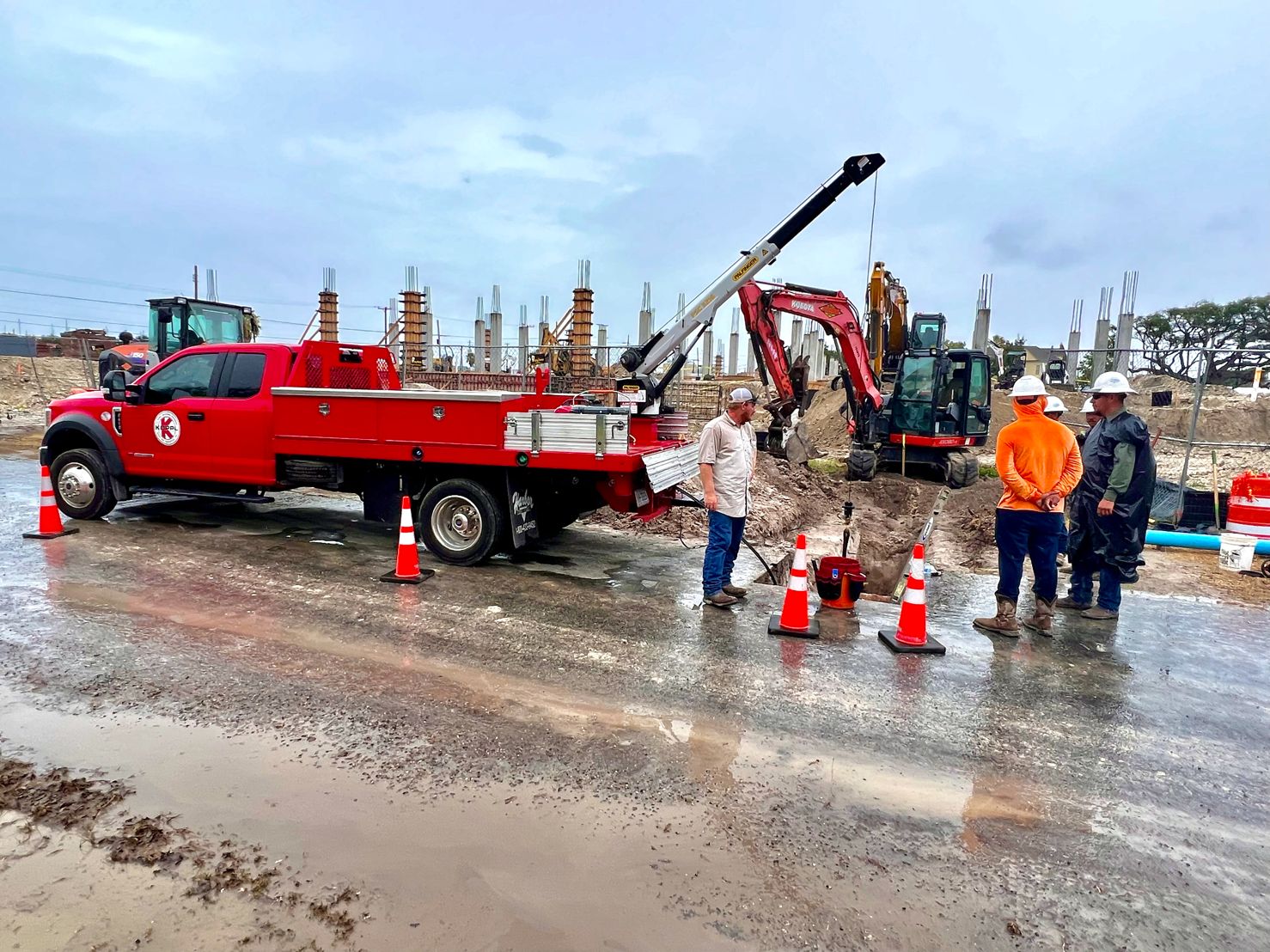 A Koppl flatbed truck and excavator staged for bypass work at a construction site