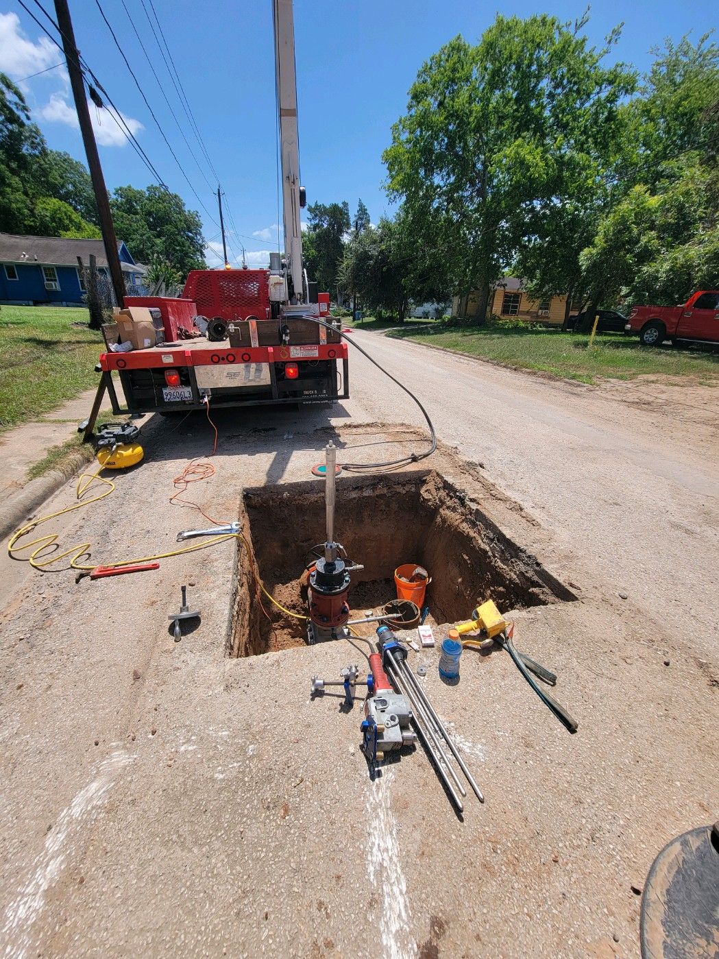 A Koppl crane truck positioned over a street excavation during a tapping job