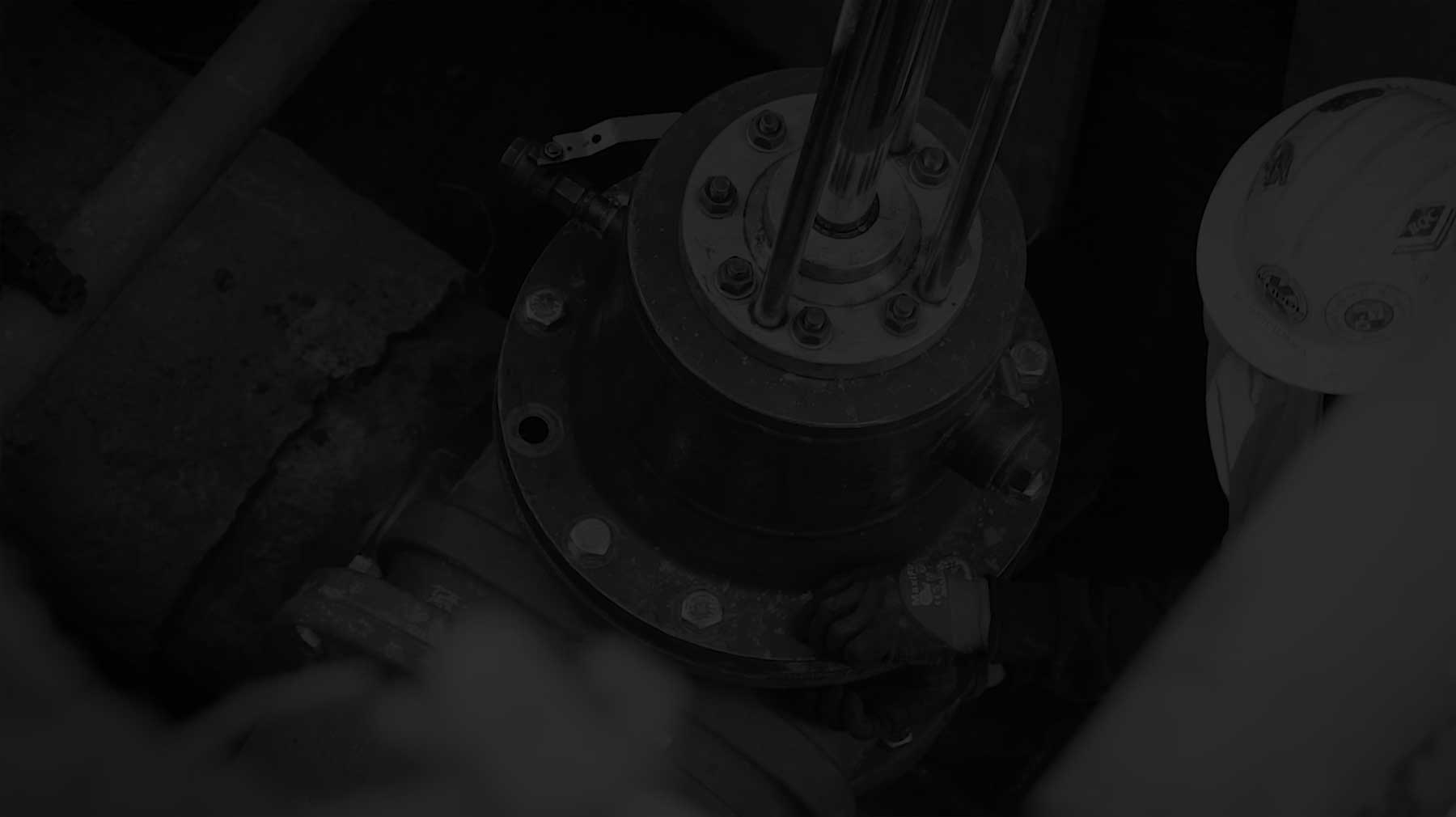A gloved Koppl technician guiding a hot tapping machine in low light