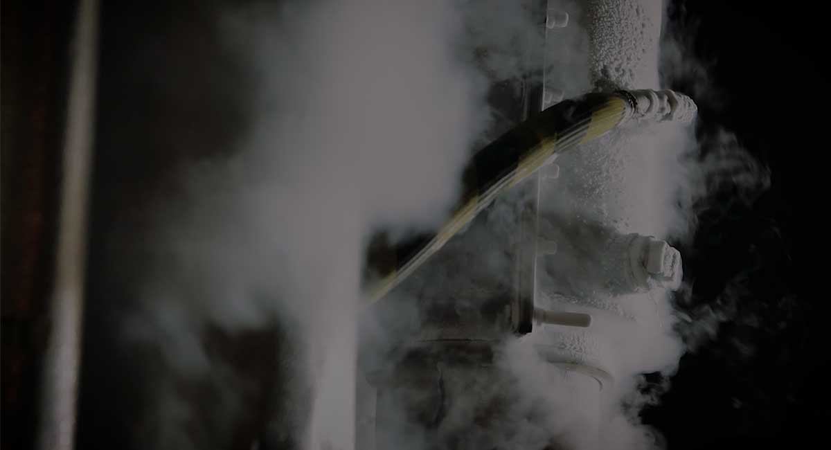 Frost coated pipe surrounded by vapor during a controlled pipe freeze